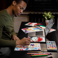 Side view of a man drawing on a tablet